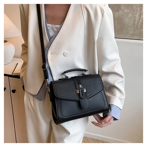 Detail of elegant black vintage crossbody bag with flap cover and metal buckle closure