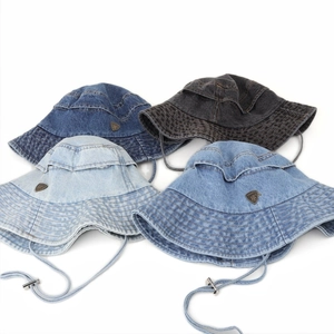 Detail of four denim bucket hats in various blue and grey tones with windproof straps