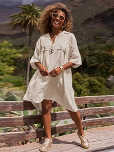 Close-up of white cotton linen shirt dress fabric and boho V-neck polo collar detail