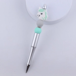 Detail of DIY beaded pen featuring a white unicorn topper and green silicone beads