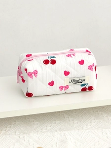 Detail of white quilted cosmetic bag with pink cherry and bow patterns and zipper