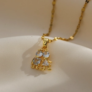 Macro detail of gold necklace with girl and boy pendant set with cubic zirconia