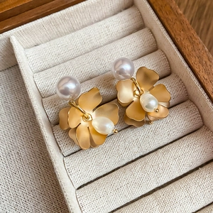 Close-up of vintage flower earrings with freshwater pearls on a jewelry display tray