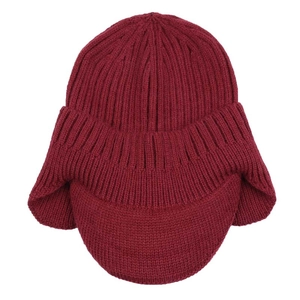 Close-up of wine red knit hat texture with ear flaps and a protective visor brim