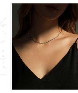 Close-up of a s925 silver choker with colorful enamel hearts on a woman's collarbone