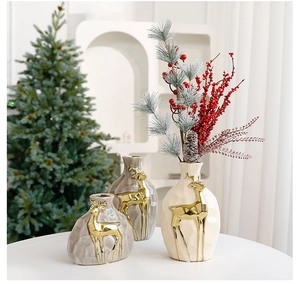 Detail of grey and beige ceramic vases with embossed golden elk patterns for Christmas decor