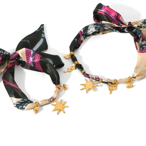 Silk floral headband set with gold sun and heart charms against white background