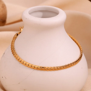 Detail view of 18K gold plated flat curb chain bracelet on a white ceramic vase