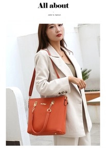 Detailed view of fashionable orange leather tote bag with elegant gold chain decoration