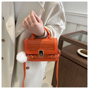 Orange mini square handbag with crocodile embossing and a fluffy white ball charm