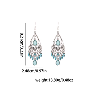 Détail des boucles d'oreilles bohèmes avec dimensions et strass bleus brillants