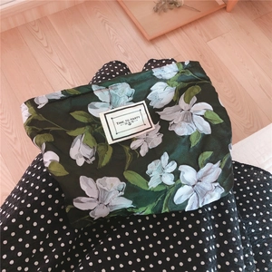 Detail of vintage green floral canvas pouch with TIME TO PARTY label on polka dot fabric