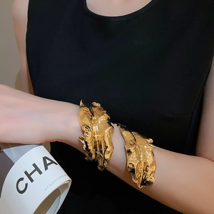 Artistic golden irregular leaf bracelet set with molten texture on black background