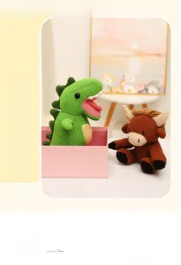 Detail of hand-knitted crochet dinosaur and cow plush toys in a gift box packaging