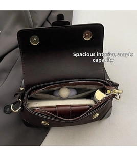 Detailed interior of a vintage brown leather shoulder bag with zipper and gold hardware