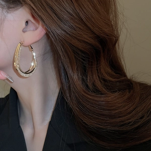Detailed close-up of gold-plated double hoop earrings with pave cubic zirconia accents