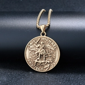 Detail of gold Saint Michael pendant necklace with protect us engraving on a black stand