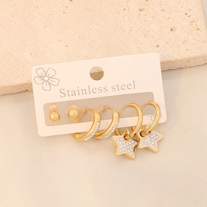 Gold stainless steel earring set with crystal studs, hoops and star pendants on a display card