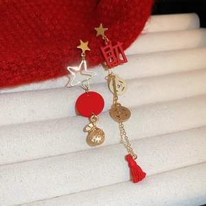 Detailed macro shot of red New Year earrings featuring Fu character and golden tassels