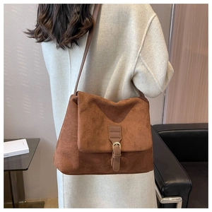 Borsa a spalla in pelle scamosciata marrone con fibbia mostrata su un modello