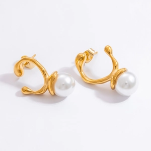 Detailed top view of 18k gold irregular earrings featuring large white pearls on a white background