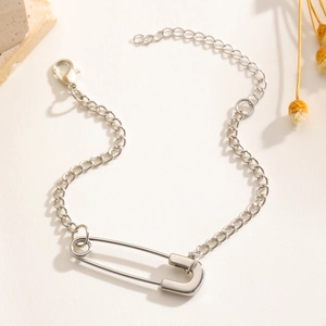 Close-up of silver paperclip link necklace with adjustable lobster clasp on beige surface