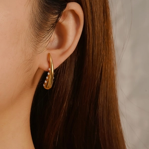 Elegant 18K gold teardrop earrings featuring sparkling pave zircons on curved metal