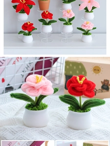 Close-up of handmade pink and red crochet sunflower potted plants on a display stand