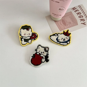Detailed view of three embroidered cartoon cat badges with neat stitching and colorful designs