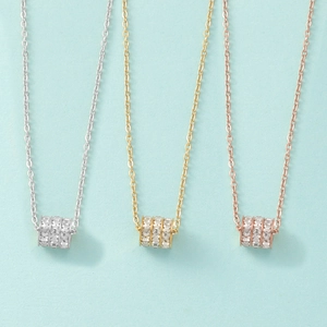 Detailed view of triple-layered cubic zirconia cylinder pendants in silver gold and rose gold