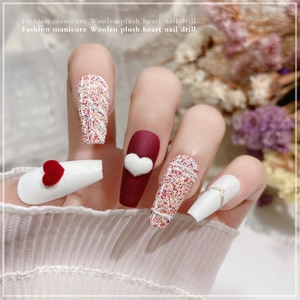 Chic autumn nail art with red plush hearts, tweed texture, and gold chain accents