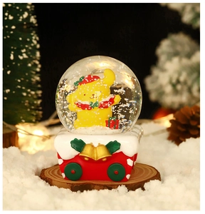 Macro view of Pompompurin snow globe with red train base and golden bells decoration