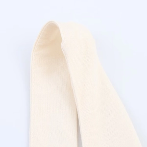 Close-up of beige knitted fabric texture showing intricate weave of midi dress material