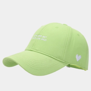 Detail of mint green baseball cap featuring white heart embroidery and stylish text