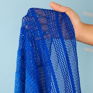 Dettaglio del tessuto plissettato blu reale con texture ondulata e maglia a rete