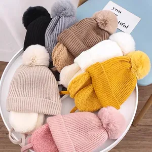 Winter knit hats for kids featuring pom-poms and ear flaps in seven assorted colors