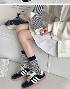 Detailansicht gestreifter Baumwollsocken mit schwarz-weißem Muster und Bären-Stickerei
