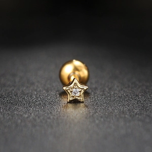 Macro detail of gold star stud earring with white zircon and screw ball back closure