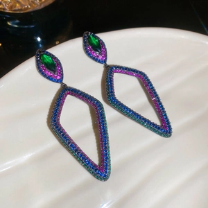 Vue macro de boucles d'oreilles losange géométriques avec zircons colorés en métal noir
