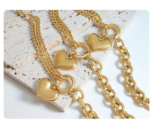 Close-up of 18K gold plated heart charms on Cuban link and O-chain bracelet