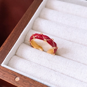 Detail of red enamel wavy ring with 24K gold plating in a premium jewelry display box