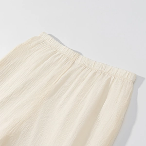 Detailed macro shot of an ivory pleated skirt with a high-elastic gathered waistband