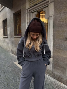 Ensemble sweat à capuche zippé gris foncé et pantalon taille haute pour femme en décor urbain