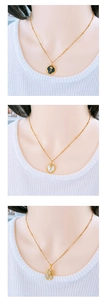 Close-up of three French style rose pendant necklaces in gold, white, and black finishes