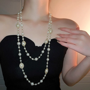 Close-up of double-layer pearl necklace with gold rhinestone oval clasps on model