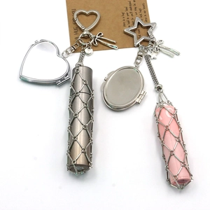 Detail showing lipstick holder keychain with heart mirror, mesh sleeve and bow charms