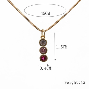 Detailed view of gold snake pendant necklace with clear, pink and red cubic zirconia gems