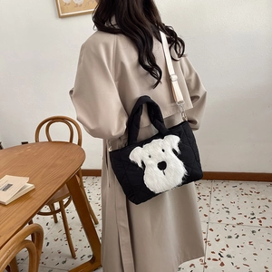Black down-padded tote bag with plush dog pattern for kids, shown in hand and crossbody
