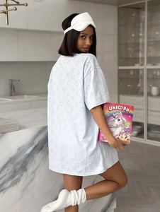 Détail d'un t-shirt oversize bleu clair à motifs de cœurs avec masque de sommeil blanc