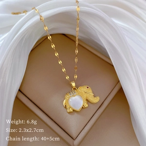 Close-up of gold elephant pendant with cat's eye stone on elegant beige display stand